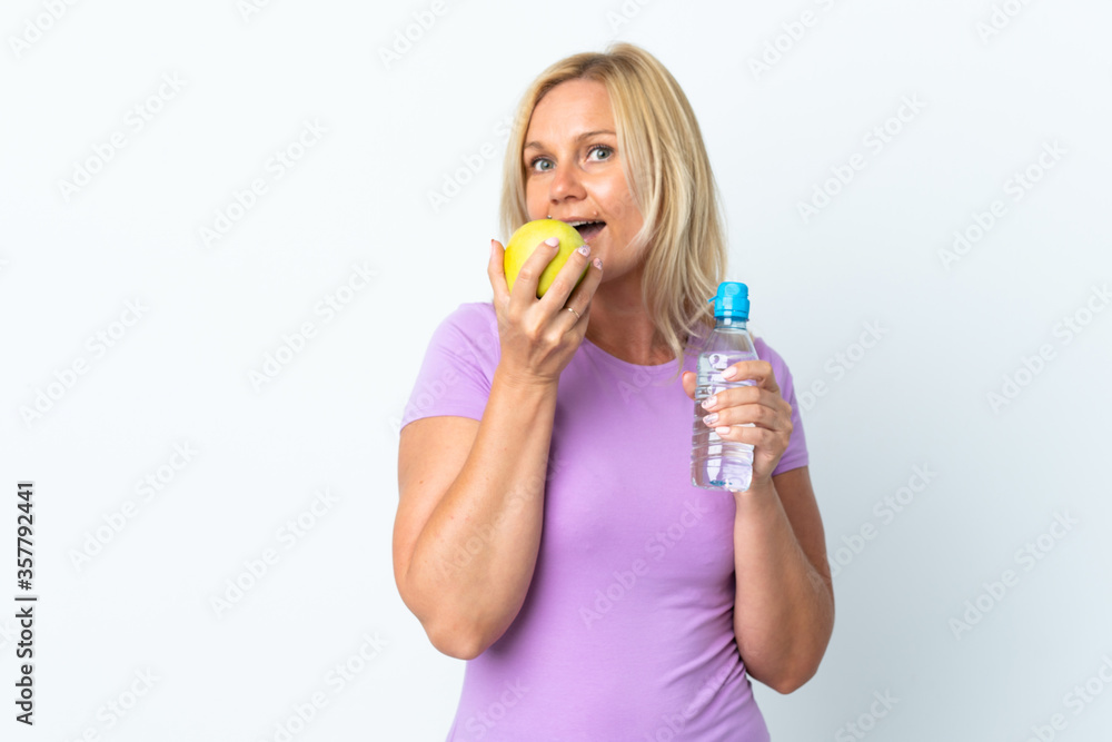 Middle age woman isolated on white background with an apple and with a bottle of water Middle age woman isolated on white background with an apple and with a bottle of water