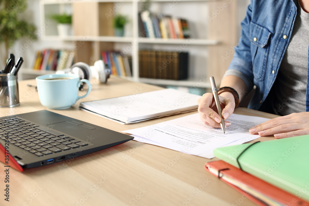 © PheelingsMedia - Student girl hands doing exam at home