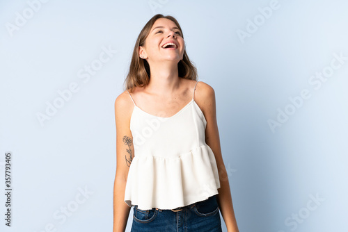 Young Lithuanian woman isolated on blue background laughing © luismolinero