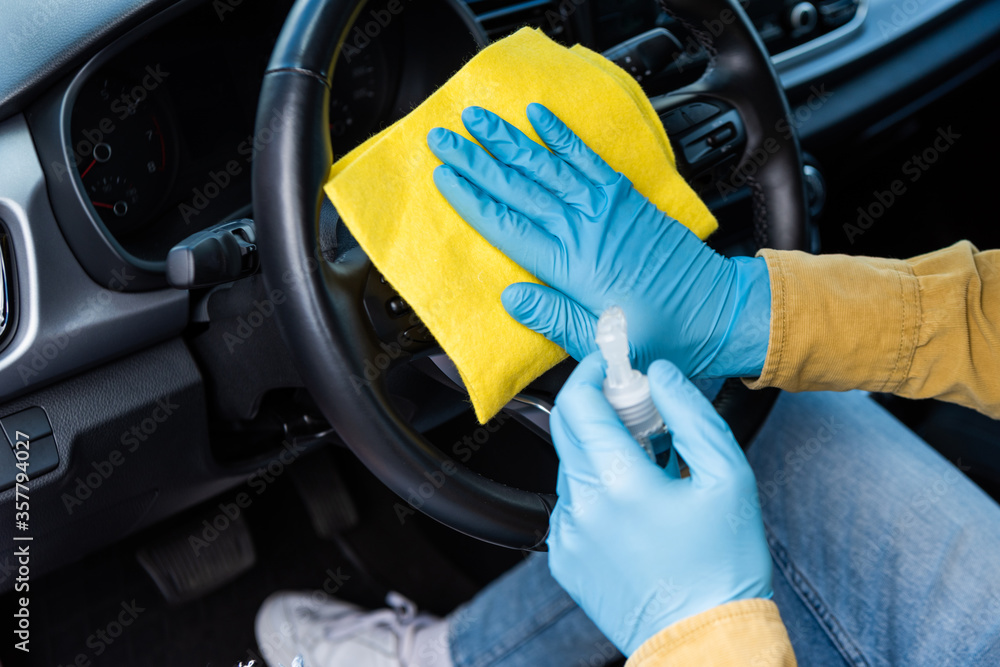cropped view of man in latex gloves using antiseptic and rag for cleaning car interior during coronavirus pandemic cropped view of man in latex gloves using antiseptic and rag for cleaning car interior during coronavirus pandemic
