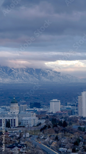 Vertical Downtown Salt Lake City with amazing view of steep snowy mountain in winter