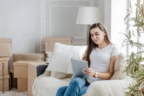 young woman with digital tablet sitting on a comfortable sofa