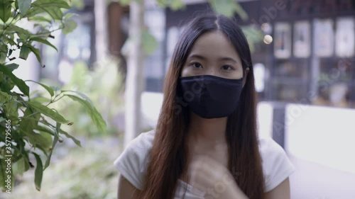 A young woman wearing a mask for protection from COVID-19 at the public area.