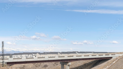 Panorama crop Concrete bridge and houses on snowy neighborhood in South Jordan City in winter