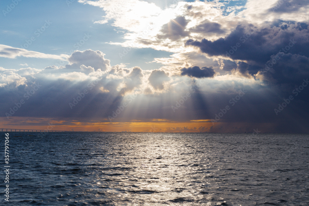 Sun rays break through clouds and illuminate the ocean, evening sunset, south africa