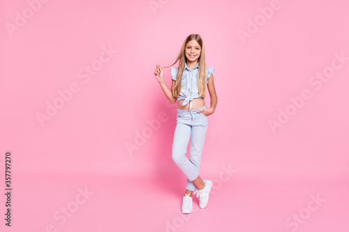Full length body size view of her she nice fashionable attractive lovely pretty content cheerful cheery preteen girl touching curl posing isolated over pink pastel color background