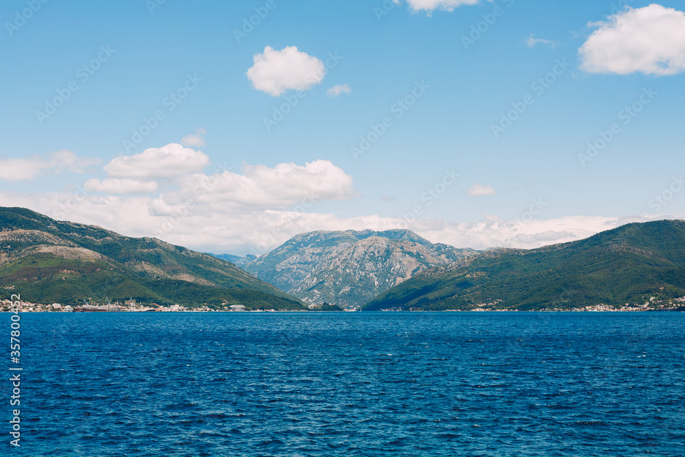 Blue sky with snow-white clouds over the Gulf of Kotor in Montenegro.