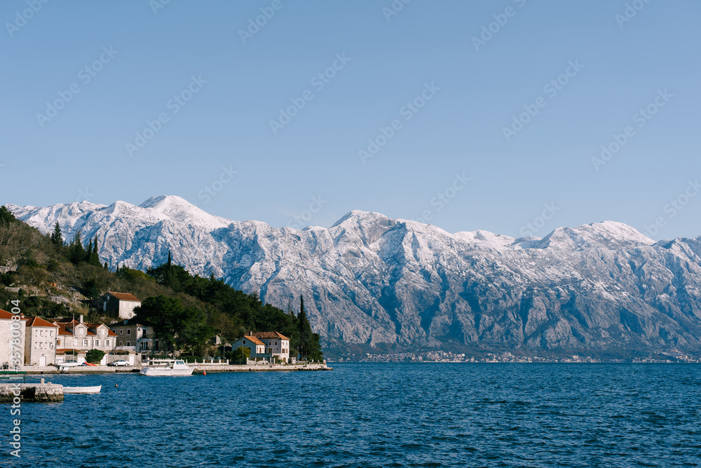 The city of Perast against the backdrop of snow-capped mountains.