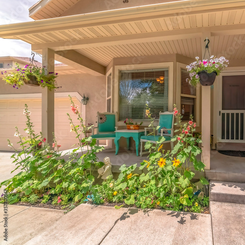 Square crop Home exterior with bay window on front porch decorated with flowers and plants
