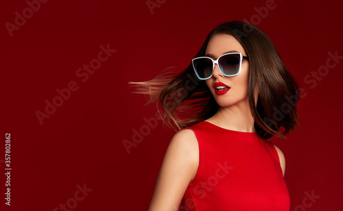 Wallpaper Mural Portrait of chic brunette girl with flying hair and luxurious make-up in white sunglasses on red background. empty space for text. Woman with healthy hair Torontodigital.ca