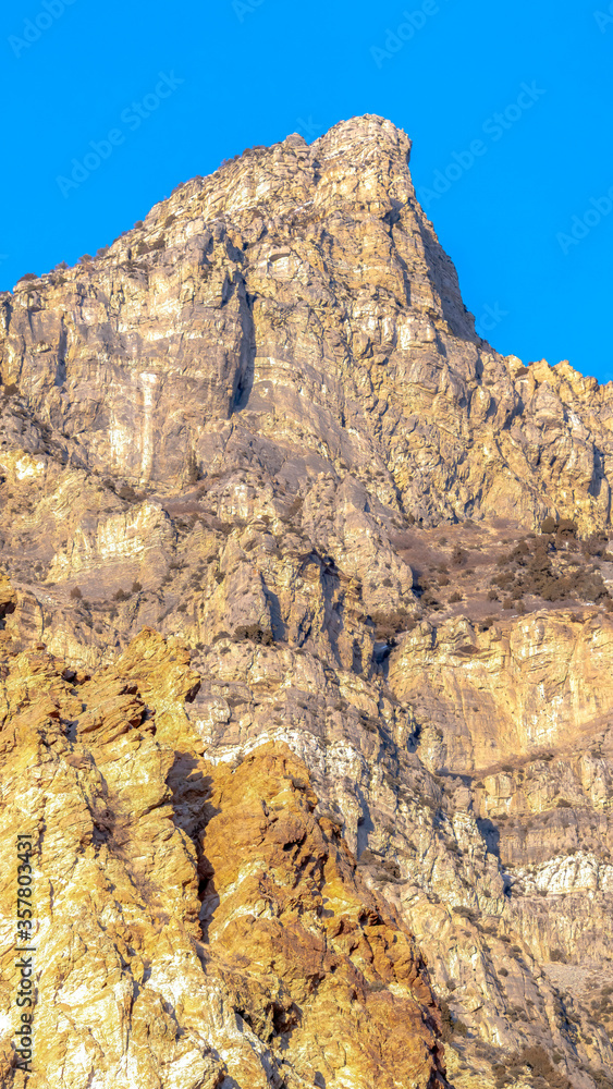 Vertical Precipitous slope of a rocky mountain gainst clear blue sky in Provo Canyon