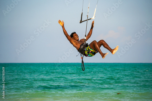 Young Attractive Muscular and Strong Athletic Black African Man Kite Surfing Instructor Teacher at the White Sand Beach photo