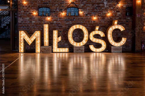 Wedding Milosc sign in Polish language (Love in English). Large letters lighting with bulb lights. Poland, Europe photo