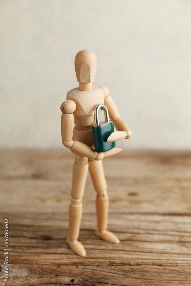 Toy man holds lock in his hands as a symbol of individual privacy, a secret. Intellectual property patent protection. Toy man holds lock in his hands as a symbol of individual privacy, a secret. Intellectual property patent protection.
