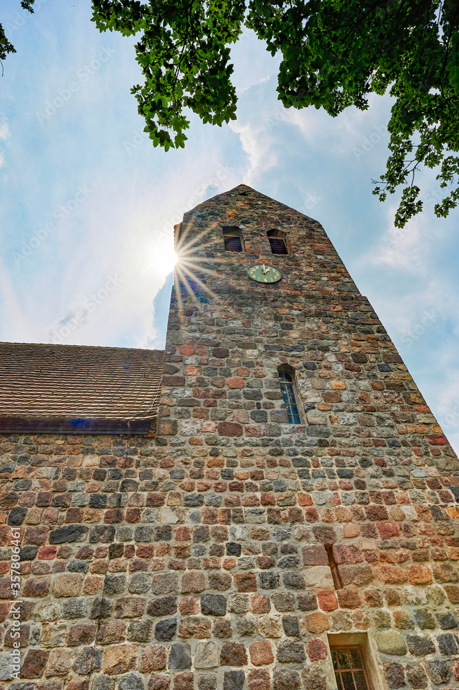 Details of a historic medieval church in Berlin, Germany. You can see parts of the building with the church tower. Sunbeams can be seen near the tower.