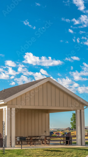 Vertical frame Building with attached picnic pavilion at a park against mountain and blue sky photo