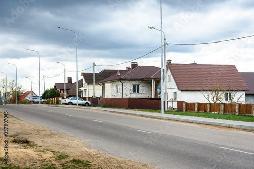 Country houses near asphalt road.