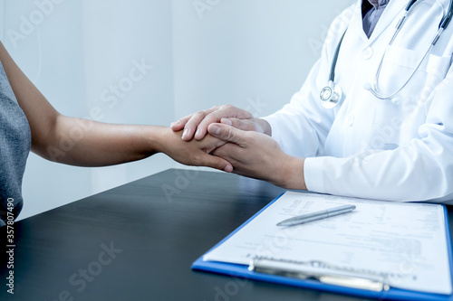Male doctors use friendly hands to hold the patient's confidence and recommend health care. Medical concepts and good health