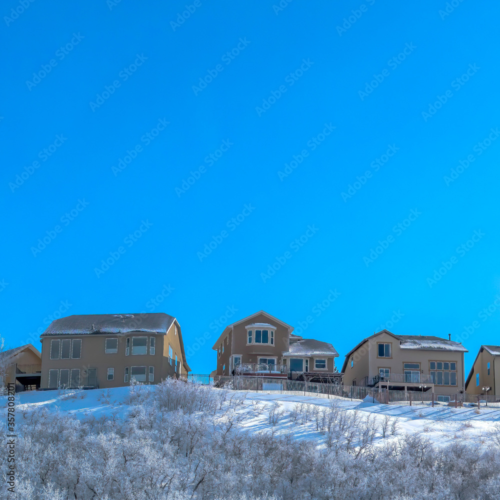 Square Row of houses on a neighborhood at the snowy terrain of Wastch Mountains Square Row of houses on a neighborhood at the snowy terrain of Wastch Mountains