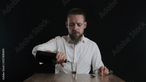 The bartender pours coffee liqueur from a bottle to cocktail glass
