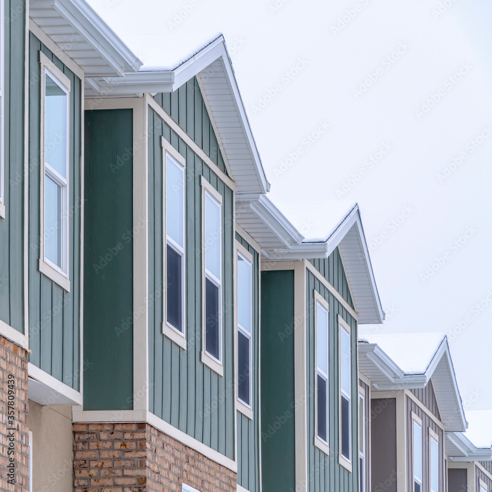 Square Vertical siding and stone brick wall at the townhomes upper storey against sky Square Vertical siding and stone brick wall at the townhomes upper storey against sky