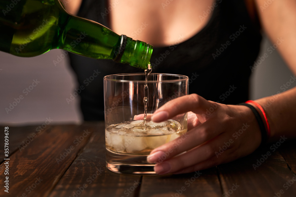 Drunk woman's hand putting on a glass of alcohol. Concept of alcoholism and addictions. Drunk woman's hand putting on a glass of alcohol. Concept of alcoholism and addictions.