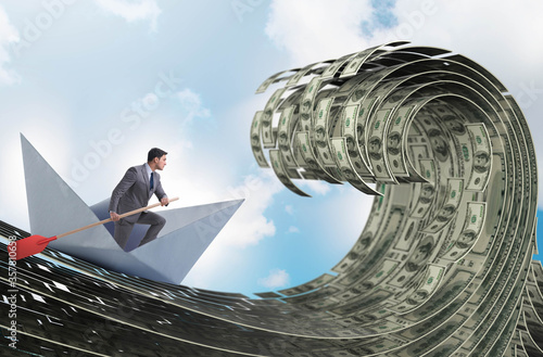 Businessman riding paper boat in dollar sea