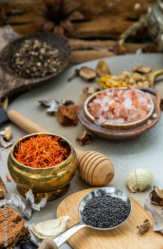Safflower and Various spices with herb in rustic style on balck background. Natural herbs medicine, Organic herbal and healthy concept, Selective focus.