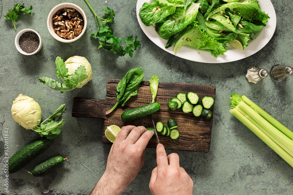 Fototapeta premium Zdrowe wegańskie jedzenie warzywa orzechy nasiona i zboża widok z góry Mężczyzna ręka przygotowuje koncepcję zielonego jedzenia