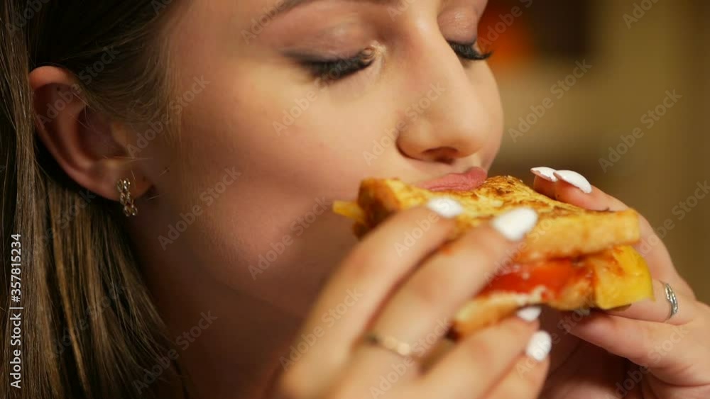 Girl passionately eats and bites a ketchup sandwich. Eat before bedtime. Girl passionately eats and bites a ketchup sandwich. Eat before bedtime.