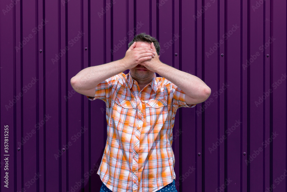 Fototapeta premium Man covers his face with his hands.Grape Compote outdoor background