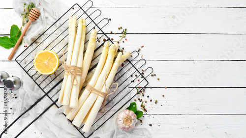 Organic white asparagus on a white wooden background. Healthy food. Top view. Free space for your text.