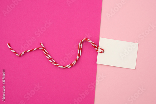 white paper rectangular tag on a rope on a colored background