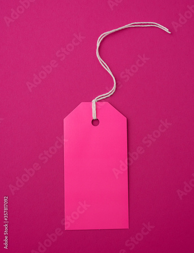 empty pink paper rectangular tag on a rope on a pink background
