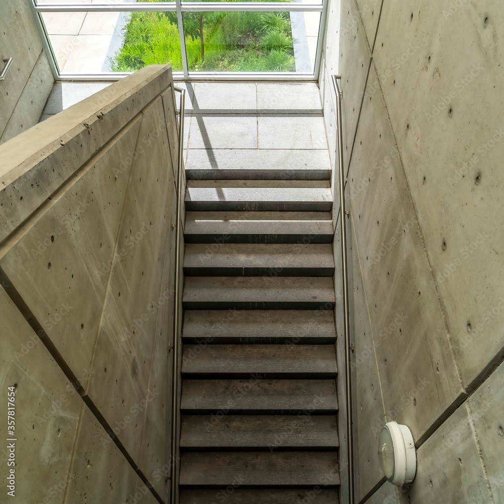 Square View from above of concrete stairway with metal handrails inside of building