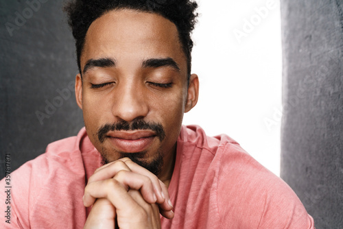 Photo of calm african american man with eyes closed posing on camera