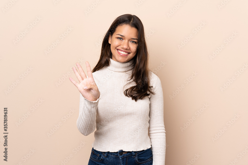 Young Colombian girl over isolated background happy and counting four with fingers Young Colombian girl over isolated background happy and counting four with fingers