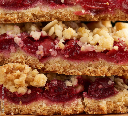 stack of square baked slices of cramble with red cherry, photo