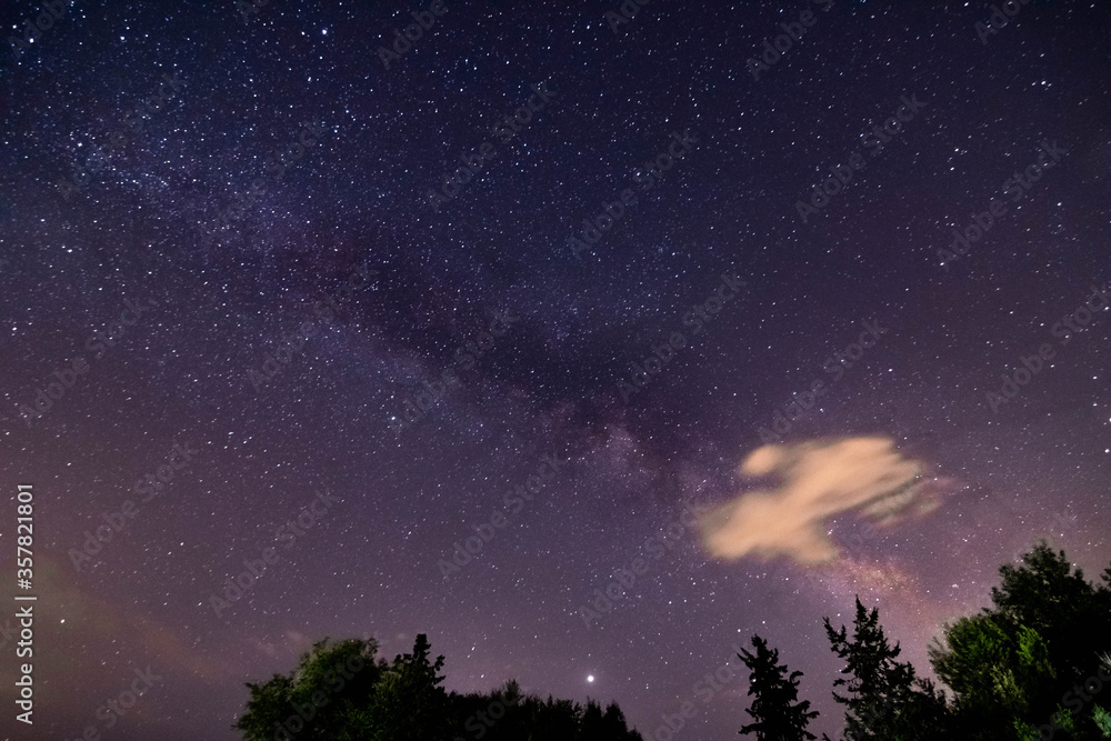 Espectacular Vía Láctea cruzando el oscuro cielo nocturno con una nube