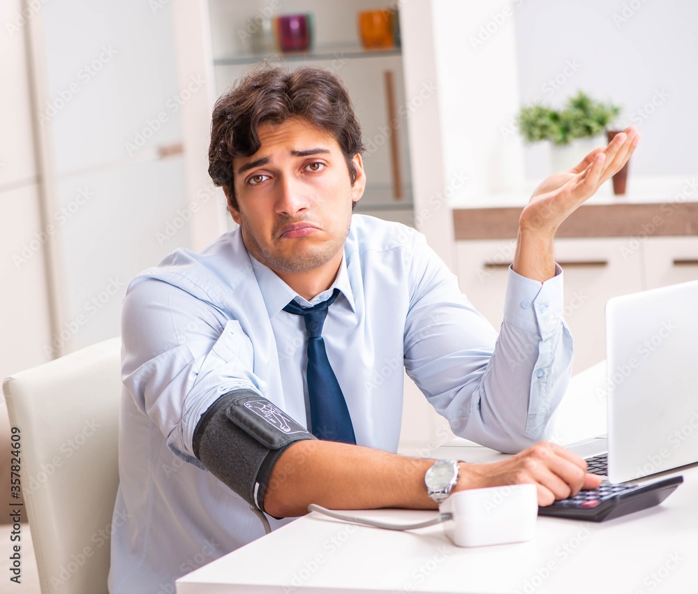 Man under stress measuring his blood pressure Man under stress measuring his blood pressure