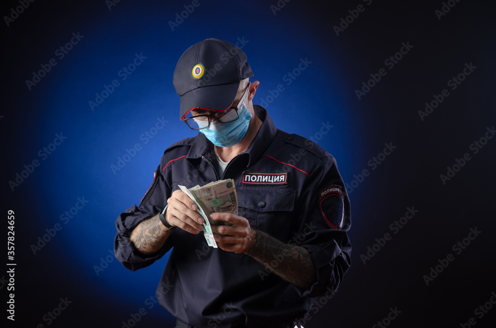 a guy in a police uniform Russian police officer in a medical mask with money in his hands. English translation of 