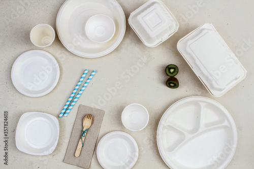Eco-friendly cutlery consisting of plates, bowls, take-away boxes, wooden spoon and and paper straw ink pot. Sustainable Living Concept.