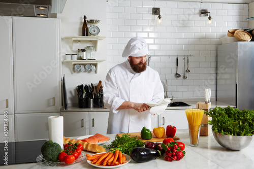Portrait of mature chef in uniform prepare his kitchen 