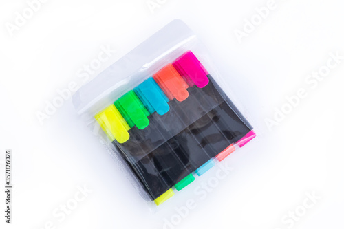 Five Colorful Markers in a Transparent Plastic Packet. Top View. Highlighters on a white isolated background. Children and Artist Pens. Office Highlighters. Pack of Yellow  Green  Blue  Orange   Pink.