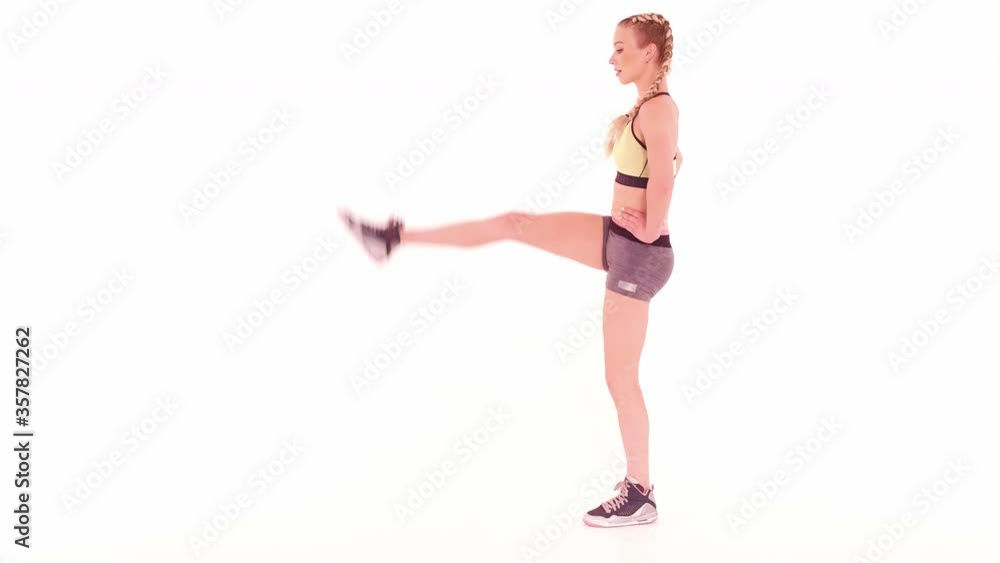 Fitness trainer doing alternate leg kick with hands on hips. Sports video tutorials isolated on white. Health care concept. Sports concept. tinted footage. Prores 422. Fitness trainer doing alternate leg kick with hands on hips. Sports video tutorials isolated on white. Health care concept. Sports concept. tinted footage. Prores 422.