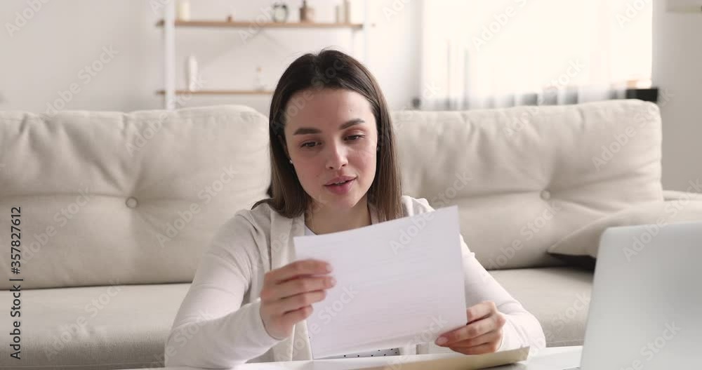 Curious young 20s girl opening envelope with correspondence, reading paper letter, excited by good news. Overjoyed happy female student received university admission notification or grant payment. Curious young 20s girl opening envelope with correspondence, reading paper letter, excited by good news. Overjoyed happy female student received university admission notification or grant payment.