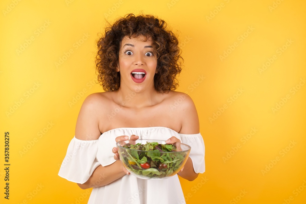 Wow. Beautiful female half-length front portrait isolated on gray studio background. Young emotional surprised woman standing with open mouth. Human emotions, facial expression concept. Trendy colors. Wow. Beautiful female half-length front portrait isolated on gray studio background. Young emotional surprised woman standing with open mouth. Human emotions, facial expression concept. Trendy colors.