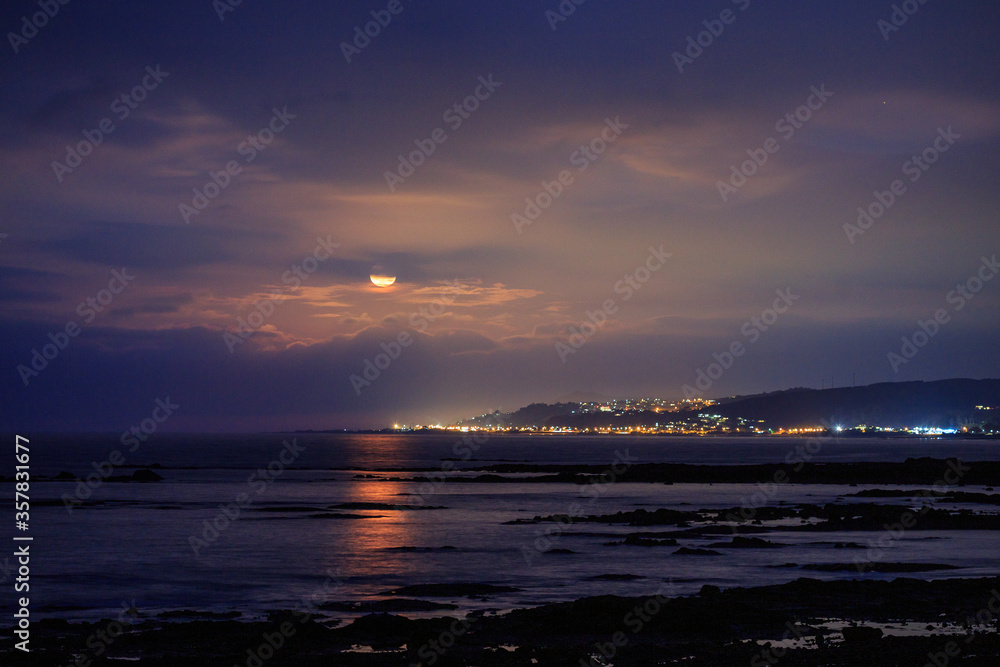 Moon rise over coastal city