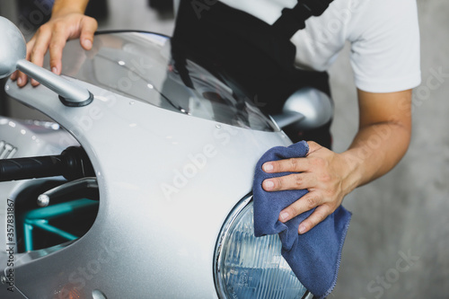 A man cleaning motorcycle - motorcycle detailing (or valeting) concept. Selective focus. © kamonrat