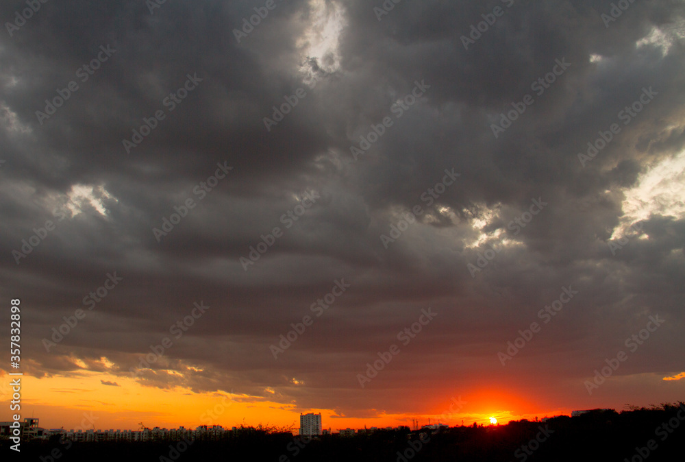 grey rainy clouds with orange sunset bottom